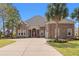 Beautiful brick home featuring a large driveway, manicured lawn, and mature palm trees offering great curb appeal at 2039 Woodburn Dr., Myrtle Beach, SC 29579
