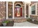 Inviting front porch with brick columns, colorful chairs, decorative plants, and attractive front door at 2039 Woodburn Dr., Myrtle Beach, SC 29579