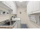 Convenient laundry room with white cabinets, granite sink, and washer and dryer, with custom shelving at 2039 Woodburn Dr., Myrtle Beach, SC 29579