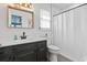 Elegant bathroom with a dark vanity, framed mirror, and white shower curtain, showcasing modern style at 205 Lander Dr., Conway, SC 29526