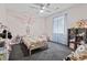 Bright bedroom with a ceiling fan, gray carpet, and a single bed decorated with a butterfly on the wall at 205 Lander Dr., Conway, SC 29526