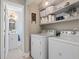 Laundry room with a washer, dryer, shelves, and a glimpse into a well-lit bathroom at 205 Lander Dr., Conway, SC 29526