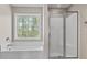 Bathroom featuring a window above a tub and a glass door shower at 211 Oak Landing Dr., Conway, SC 29527
