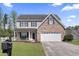 Charming two-story home featuring a brick accent, an attached garage and a well manicured lawn at 211 Oak Landing Dr., Conway, SC 29527