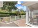 Back deck with white railing, lush landscaping, and a view of the screened-in porch at 25 Bentley Ct., Pawleys Island, SC 29585