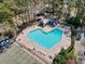 Aerial view of a heart-shaped pool with ample seating and parking surrounded by trees at 25 Bentley Ct., Pawleys Island, SC 29585