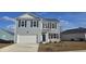 Charming two-story home featuring light gray siding, a two-car garage, and dark blue shutters set against a bright blue sky at 2824 Riverboat Way, Conway, SC 29526