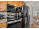 This kitchen boasts black appliances and wood cabinets, creating a functional and stylish cooking space at 3015 Old Bryan Dr. # 9-7, Myrtle Beach, SC 29577