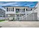 Two story beach house featuring elevated structure, white siding, and a double staircase at 329 46Th Ave. N, North Myrtle Beach, SC 29582