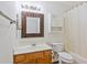 Cozy bathroom with a wooden-framed mirror and ample storage space above the toilet at 349 Robin Hood Circle, Little River, SC 29566