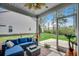 Screened-in porch with comfortable blue cushioned seating and a view of the lush green backyard at 3613 Pitchers Pl., Little River, SC 29566