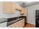 Well-lit kitchen with wood cabinets, black appliances, and a granite countertop at 3741 Block House Way # 736, Myrtle Beach, SC 29577