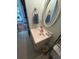 Compact bathroom featuring a single sink vanity, neutral tiles, and an oval mirror at 4396 Baldwin Ave. # C-24, Little River, SC 29566