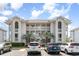 Three story condo building with white railings, beautiful windows, and front parking at 4409 Eastport Blvd. # E2, Little River, SC 29566