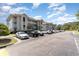 View of gray condo buildings with parking spots available, and blue skies above at 4409 Eastport Blvd. # E2, Little River, SC 29566