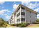Exterior of condo featuring enclosed porches and manicured landscaping at 4409 Eastport Blvd. # E2, Little River, SC 29566