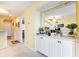 Hallway featuring a decorative mirror, white cabinets, and views into the living areas at 4409 Eastport Blvd. # E2, Little River, SC 29566