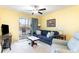 Bright living room featuring comfortable blue sofa, ceiling fan, and sliding glass doors to the deck at 4409 Eastport Blvd. # E2, Little River, SC 29566