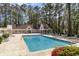Community pool with lounge chairs surrounded by a building and green trees at 4409 Eastport Blvd. # E2, Little River, SC 29566