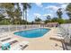 Community pool surrounded by lounge chairs and white fencing in wooded area at 4409 Eastport Blvd. # E2, Little River, SC 29566