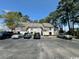 Condominium complex surrounded by tall trees, featuring ample parking and neutral toned facade at 4482 Little River Inn Ln. # 2004, Little River, SC 29566