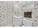 Well-maintained bathroom with a single sink vanity, floral wallpaper, and a convenient toilet at 4679 Wild Iris Dr. # 103, Myrtle Beach, SC 29577