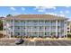Three-story condo building with ample parking and exterior stairs to each unit at 4679 Wild Iris Dr. # 103, Myrtle Beach, SC 29577