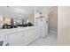 Open kitchen with white cabinets and breakfast bar overlooking the living area at 4679 Wild Iris Dr. # 103, Myrtle Beach, SC 29577