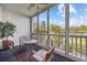 Comfortable screened porch with seating and a peaceful view of trees and landscaping at 4679 Wild Iris Dr. # 103, Myrtle Beach, SC 29577