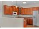 Kitchen area features cherry cabinets, white appliances, breakfast bar and pendant lighting at 621 Banks Dr. # 12-1, Myrtle Beach, SC 29588