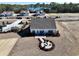 Aerial view of a new home featuring a circular patio with a fire pit, set against a backdrop of a serene lake at 66 Northbrook Dr, Murrells Inlet, SC 29576