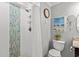 Modern bathroom with tiled shower, a toilet, a mirror, and decorative beach-themed accents at 720 North Waccamaw Dr. # 312, Murrells Inlet, SC 29576