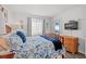 Bright bedroom with floral bedding, a window with sheer curtains, and a door to the balcony at 720 North Waccamaw Dr. # 312, Murrells Inlet, SC 29576