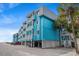 Charming beach condo building featuring light blue exteriors, white railings, and ample parking at 720 North Waccamaw Dr. # 312, Murrells Inlet, SC 29576