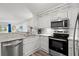 Modern kitchen featuring stainless steel appliances, white cabinetry, and a breakfast bar at 720 North Waccamaw Dr. # 312, Murrells Inlet, SC 29576