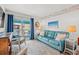 Cozy living room featuring a blue leather sofa, stylish rug, and a balcony with ocean views at 720 North Waccamaw Dr. # 312, Murrells Inlet, SC 29576
