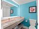 A modern bathroom with an illuminated mirror, marble countertop, toilet, and coastal-themed wall art is shown at 7200 N Ocean Blvd. N # 439, Myrtle Beach, SC 29572