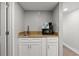 A kitchenette with a granite countertop, white cabinetry, a sink, microwave, and coffee maker is shown at 7200 N Ocean Blvd. N # 439, Myrtle Beach, SC 29572