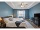 Stylish main bedroom with tray ceiling, bedside lamps, fan, and en-suite bathroom at 808 Wild Leaf Loop, Conway, SC 29526