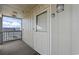 Unit 401 entrance with a white door, storm door, exterior carpet, and outside lighting at 811 N Ocean Blvd. # 401, Surfside Beach, SC 29575