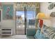 The living room features a comfy blue sofa, pelican art, and access to the balcony at 9620 Shore Dr. # 307, Myrtle Beach, SC 29572
