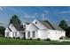 Charming white farmhouse-style home with a well-manicured lawn and a three-car garage at 974 Crooked Oak Dr., Pawleys Island, SC 29585