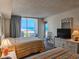 Inviting bedroom with two beds, dresser, and a sliding glass door leading to a balcony with an ocean view at 9820 Queensway Blvd. # 607, Myrtle Beach, SC 29572