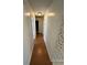 Hallway with wood flooring leads to various rooms with a light fixture and wall paper on the right at 1014 Mimosa Ct., Conway, SC 29527