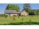 Spacious backyard featuring a well-manicured lawn, trees, and a charming home exterior at 1210 Horry Rd., Aynor, SC 29511