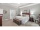 Elegant main bedroom features a four-poster bed, neutral walls, and a connecting bathroom at 1406 Seabrook Plantation Way, North Myrtle Beach, SC 29582