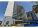 Coastal condo building featuring multiple floors, balconies, and palm trees, and a blue truck at 2001 S Ocean Blvd. # 207, Myrtle Beach, SC 29577