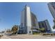 A lovely multi story building with a bright blue sky overhead and a sidewalk along the street at 2001 S Ocean Blvd. # 207, Myrtle Beach, SC 29577