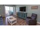Cozy living room with balcony access, a plush recliner, and comfortable furnishings at 2001 S Ocean Blvd. # 207, Myrtle Beach, SC 29577