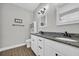 Bathroom featuring double sinks with granite countertops, a linen closet, and tile-look floors at 3004 Fiddler Ct., Loris, SC 29569